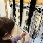 Kinsie Young weaves on her child-size robe for the Youth Pride Robe project. (Photo courtesy of Lily Hope)