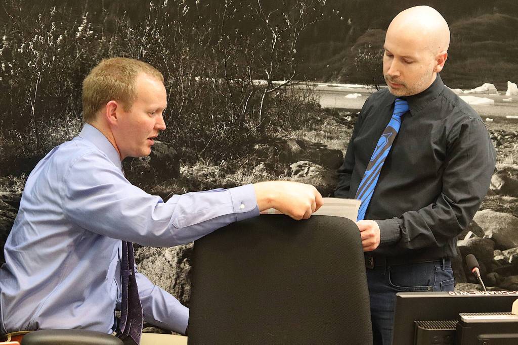 Juneau Assembly member Paul Kelly (right) discusses legal options with City Attorney Robert Palmer during a break in a meeting Monday where a resolution Kelly introduced calling for a bilateral peace agreement in Israel and Palestine was debated. (Mark Sabbatini / Juneau Empire)