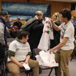 Juneau residents calling for a ceasefire in Gaza put on t-shirts with slogans declaring their cause before testifying on a resolution calling for a bilateral peace agreement in Israel and Palestine considered by the Juneau Assembly on Monday night. (Mark Sabbatini / Juneau Empire)
