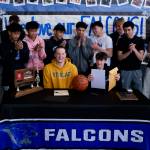 Thunder Mountain High School seniors James Polasky, left, and Samuel Lockhart, right, are applauded by teammates after signing letters of intent on Thursday in the TMHS commons to play college basketball. Polasky will attend St. Olaf in Minnesota and Lockhart will attend Edmonds College in Washington state. (Klas Stolpe / For the Juneau Empire)