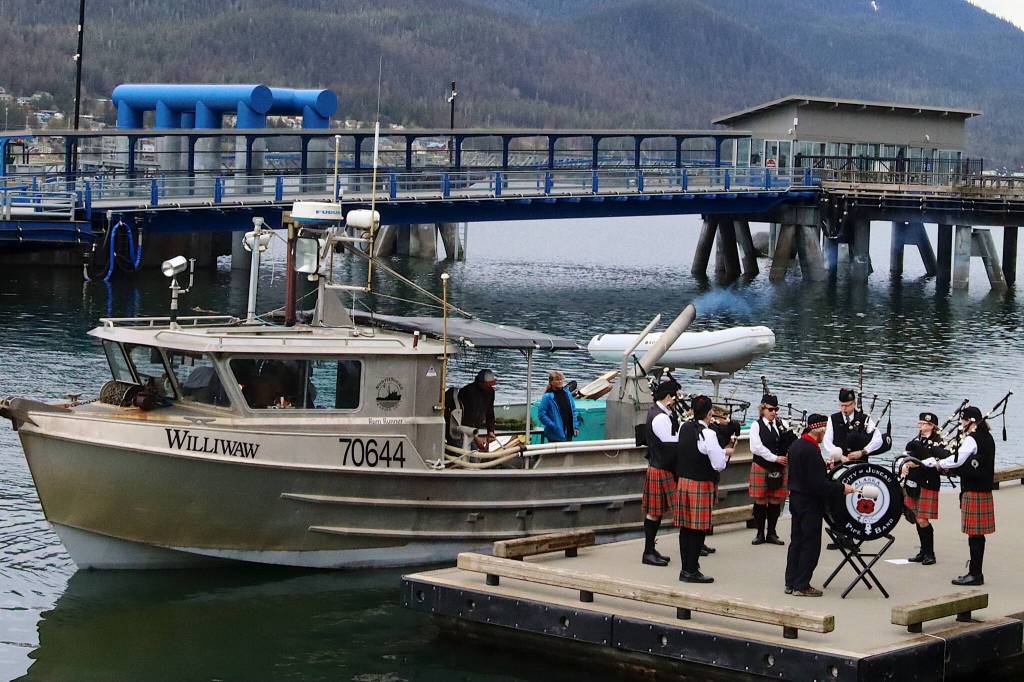 Family members of Ronald Hakala, a longtime commercial fisherman who died in April, prepare to lay a wreath on the sea from F/V Williwaw as the Juneau Pipe Band performs a sendoff during the annual Blessing of the Fleet on Saturday morning at the Alaska Commercial Fishermens Memorial. (Mark Sabbatini / Juneau Empire)