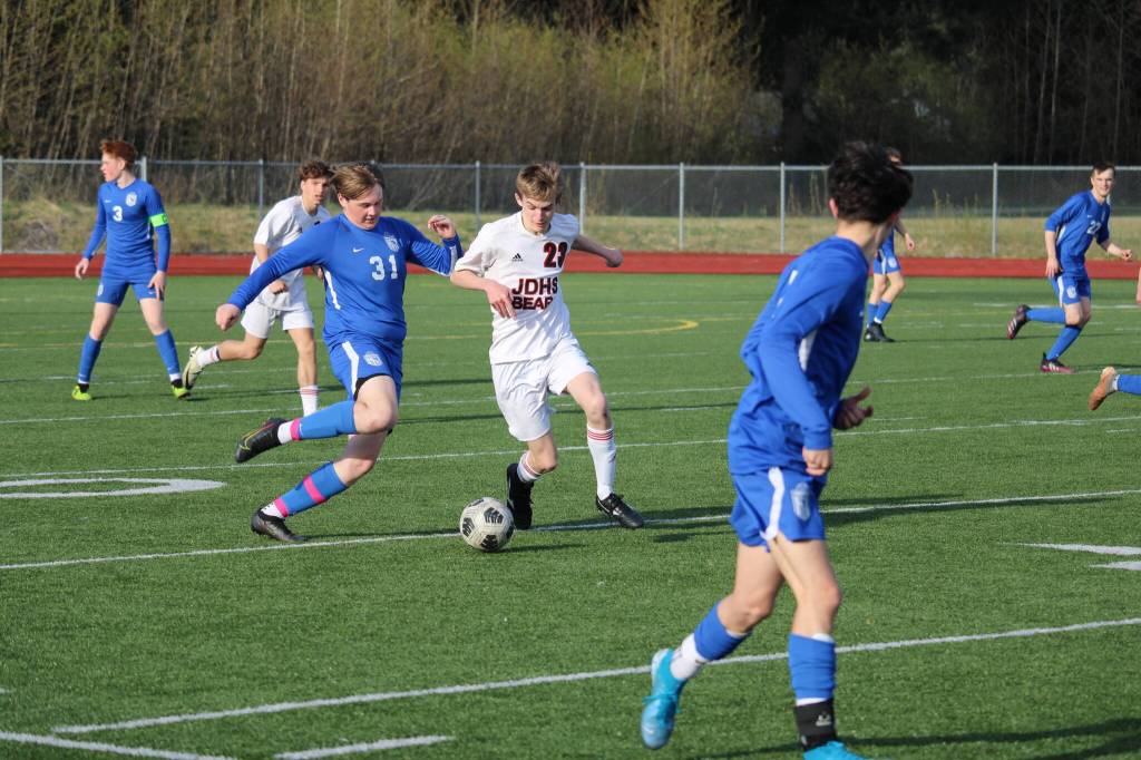 Thunder Mountain High Schools Camdyn Landvik (31) and Juneau Douglas High School: Yadaa.at Kalés Owen Rumsey fight for the ball during Thursdays game at TMHS. (Photo by Tory Bennetsen)