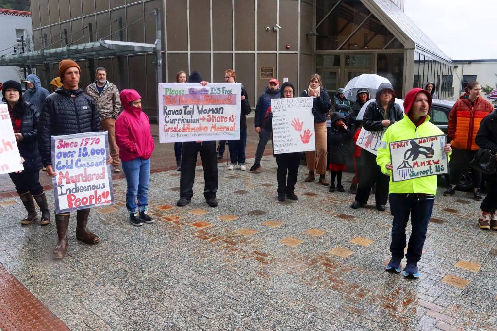 People hold signs detailing abuses against Indigenous persons during a rally in front of the Alaska State Capitol on Sunday to commemorate the annual Missing and Murdered Indigenous Persons Awareness Day. (Mark Sabbatini / Juneau Empire)