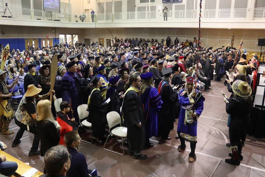 The Mt. Juneau Tlingit and Woosh.Ji.Een Dancers offer a welcome procession to graduating students at the University of Alaska Southeast as they enter the UAS Recreational Center for their commencement ceremony on Sunday. (Mark Sabbatini / Juneau Empire)