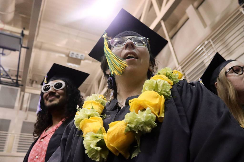 Elizabeth Kell (right) and Ricardo Medina Soler enter the University of Alaska commencement ceremony to receive their degrees on Sunday. (Mark Sabbatini / Juneau Empire)