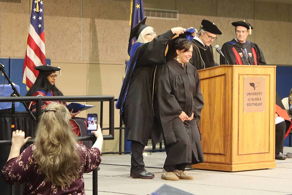 Courtney Hart receives her hood from Professor Ginny Eckert as one of two doctorate graduates during the University of Alaska Southeast commencement ceremony on Sunday at the UAS Recreation Center. (Mark Sabbatini / Juneau Empire)