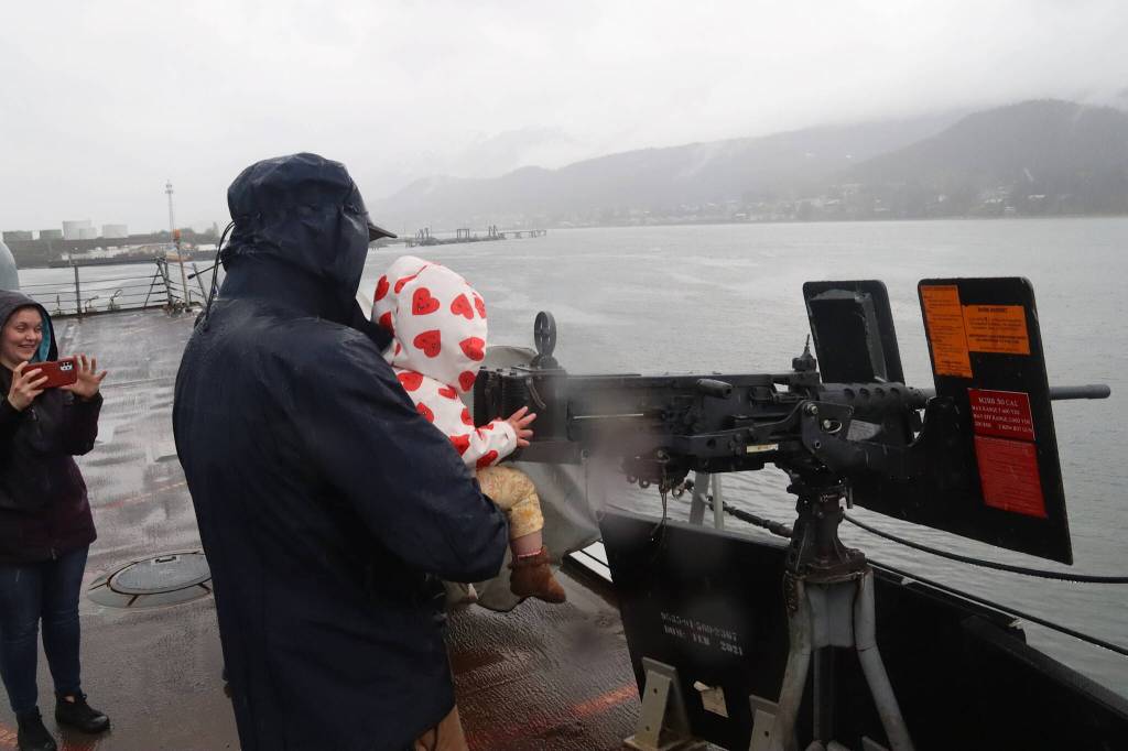 Ripley Wallace and her father, Tyler, aim a .50 caliber heavy machine gun aboard the U.S. Navys USS William P. Lawrence during a tour Sunday. (Mark Sabbatini / Juneau Empire)