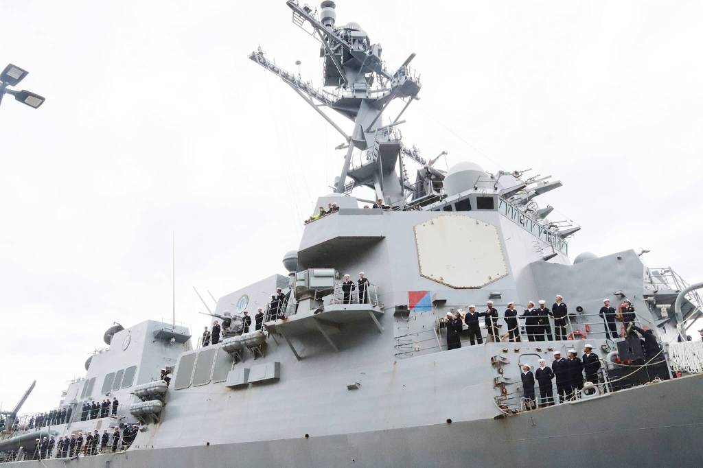 Crew members aboard the USS William P. Lawrence stand attention on the decks as the U.S. Navy destroyer arrives in Juneau on Saturday afternoon. (Mark Sabbatini / Juneau Empire)