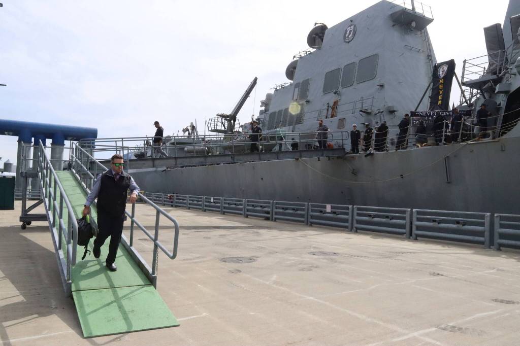 Officers and other crew aboard the USS William P. Lawrence prepare to disembark after the U.S. Navy destroyer docks in Juneau on Saturday afternoon. (Mark Sabbatini / Juneau Empire)