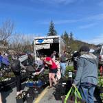 Aproned, bearded and ball-capped Ed Buyarksi, owner of Eds Edible Landscaping, stays busy with shoppers near his truckload of plants and trees at Saturdays Juneau Garden Club plant sale in the Safeway parking lot. (Laurie Craig / Juneau Empire)