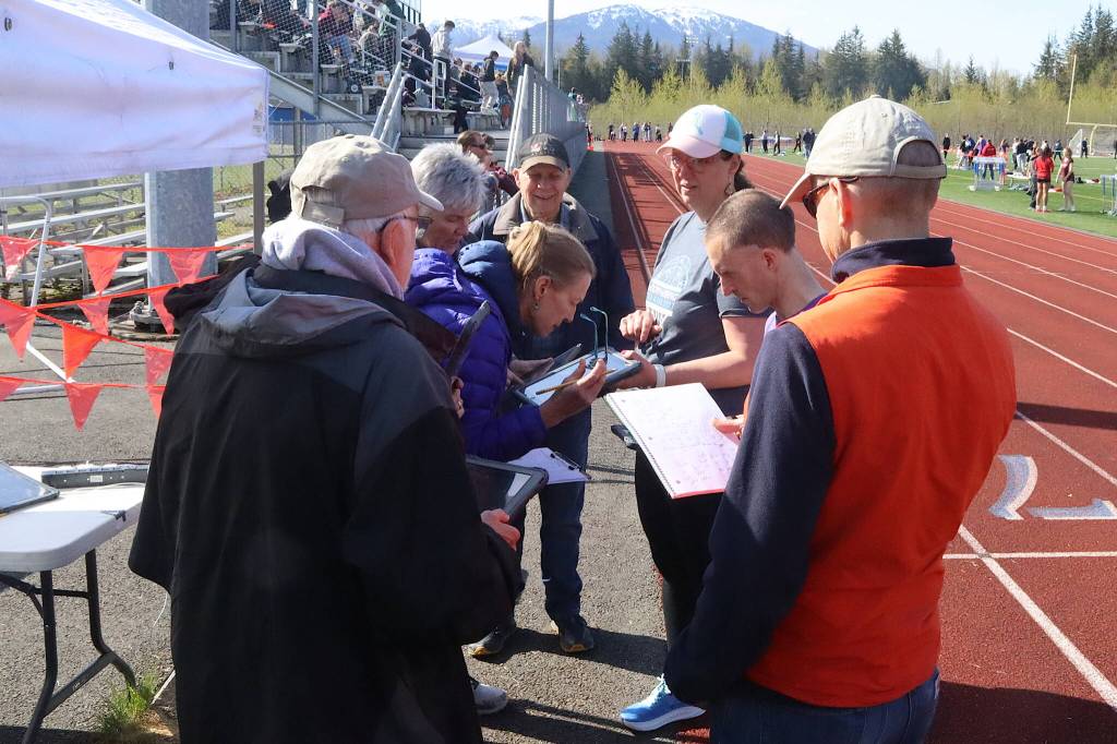 Timekeepers huddle to determine the official results of a race during the Capital Invitational Track and Field Meet on Saturday at Thunder Mountain High School. (Mark Sabbatini / Juneau Empire)