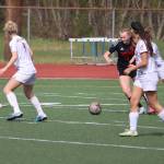 Alyssa Travis (17) tries to get the ball out of traffic for Juneau-Douglas High School: Yadaa.at Kalé during Saturdays game against Ketchikan High School at Adair-Kennedy Field. (Mark Sabbatini / Juneau Empire)