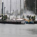 Capital City Fire/Rescue firefighters work to contain a fire that spread to three boats in Douglas Harbor on Monday evening. (Mark Sabbatini / Juneau Empire)