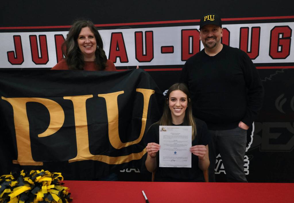 Juneau-Douglas High School: Yadaa.at Kalé senior Mila Hargrave, shown with mother Sarah and father Dallas, signed a national letter of intent on Monday at the George Houston Gymnasium to attend Pacific Lutheran University and play softball for the Lutes. (Klas Stolpe / For the Juneau Empire)