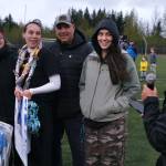 Thunder Mountain High School senior Shaelyn Newport and family listen to a teammate during the Falcons final home game Monday at Falcons Field. (Klas Stolpe / For the Juneau Empire)