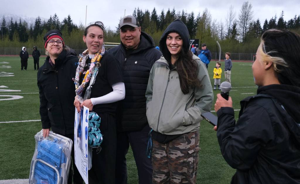 Thunder Mountain High School senior Shaelyn Newport and family listen to a teammate during the Falcons final home game Monday at Falcons Field. (Klas Stolpe / For the Juneau Empire)