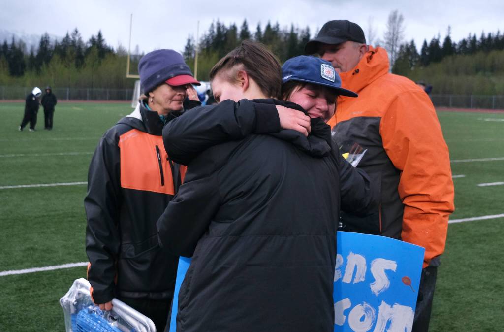 Thunder Mountain High School senior manager Lauren Stichert hugs sophomore sister Randy Stichert as their parents look on during the Falcons girls soccer senior night Monday at Falcons Field. (Klas Stolpe / For the Juneau Empire)