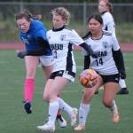 Thunder Mountain High School senior Kaidree Hartman (36) puts a shot past Juneau-Douglas High School: Yadaa.at Kalé junior Adelyn Buss (3) and sophomore Tearamae Alexander (14) during the Falcons final home game Monday at Falcons Field. (Klas Stolpe / For the Juneau Empire)