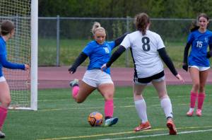 Thunder Mountain High Schools Miley Andrews (16) clears a ball past JDHS Crimson Bears Parker Boman (8) during the Falcons final home game Monday at Falcons Field. (Klas Stolpe / For the Juneau Empire)