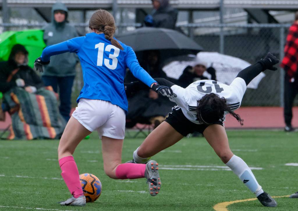 Thunder Mountain High Schools Piper Blackgoat (13) and Juneau-Douglas High School: Yadaa.at Kalés Cadence Plummer go for a ball during the Falcons final home game Monday at Falcons Field. (Klas Stolpe / For the Juneau Empire)