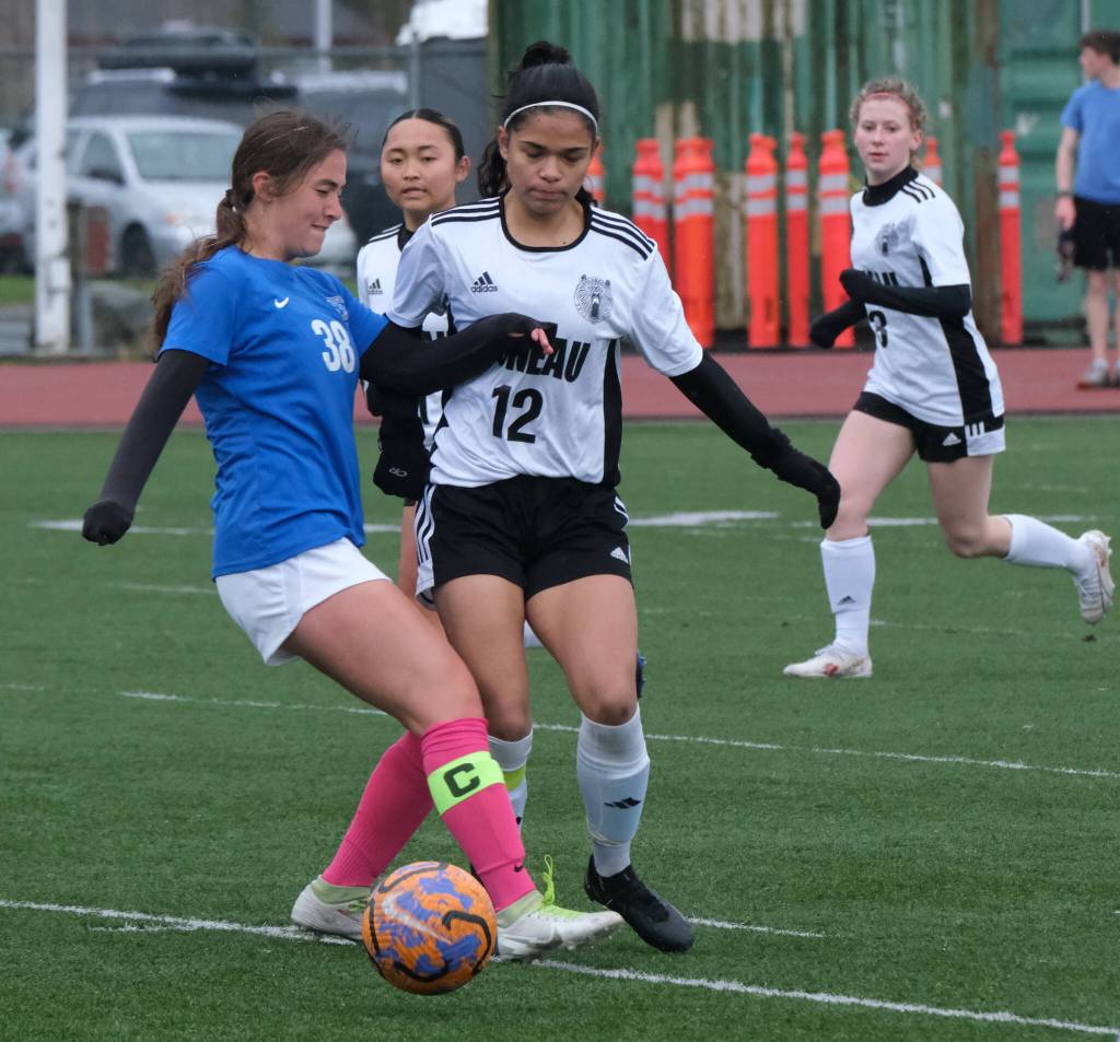 Thunder Mountain High School senior Adella Dihle (38) and Juneau-Douglas High School: Yadaa.at Kalé senior Cadence Plummer (12) work for a ball during the Falcons final home game Monday at Falcons Field. (Klas Stolpe / For the Juneau Empire)