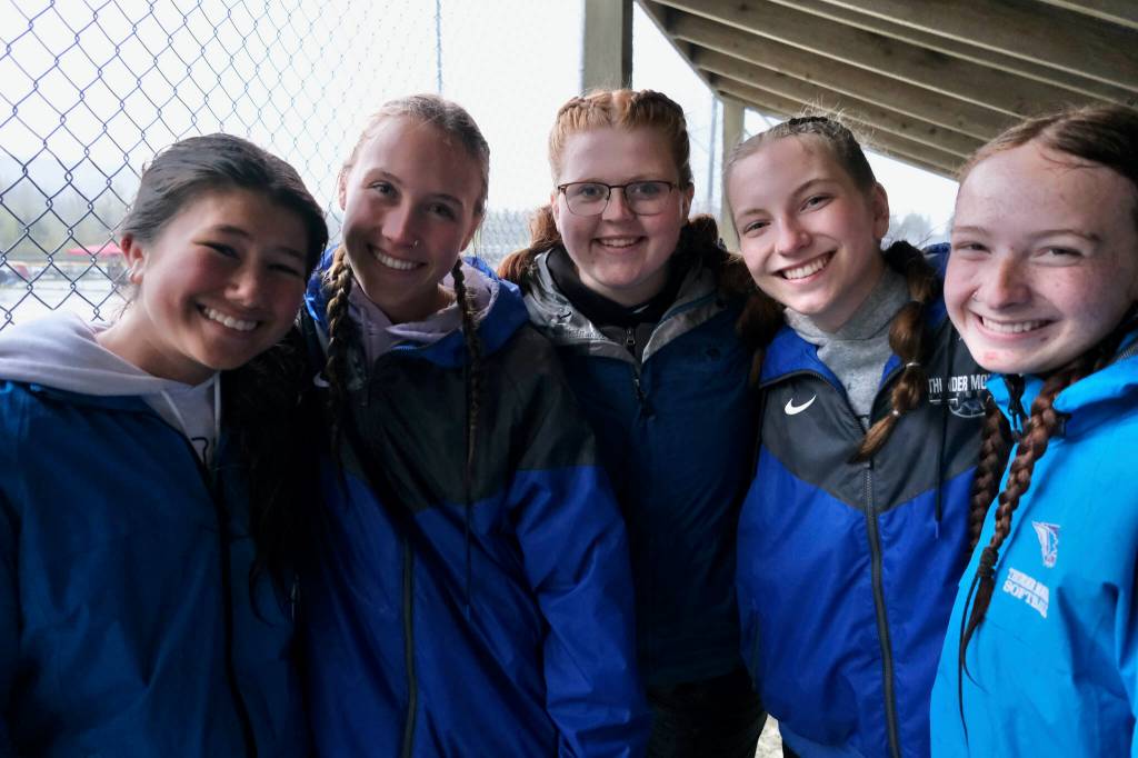 Thunder Mountain High School softball seniors Aliza Mesdag, Ashlyn Gates, Kara Strong, Jenna Dobson and Jack Lovejoy huddle in the dugout before their final career home game Tuesday against Juneau-Douglas High School: Yadaa.at Kalé at Dimond Park Fields. (Klas Stolpe, For the Juneau Empire)