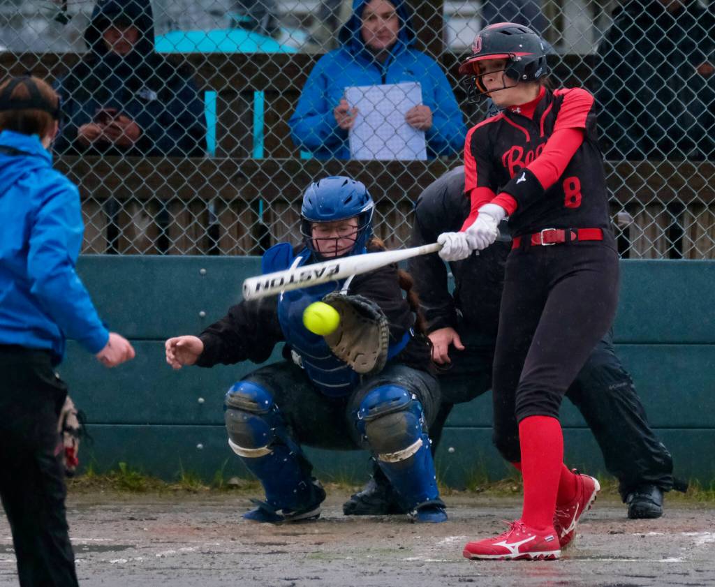 Thunder Mountain High School senior catcher Kara Strong awaits a pitch as Juneau-Douglas High School: Yadaa.at Kalé senior batter Mila Hargrave swings during the Falcons 10-9 win over the Crimson Bears on Tuesday at Dimond Park Fields. (Klas Stolpe, For the Juneau Empire)