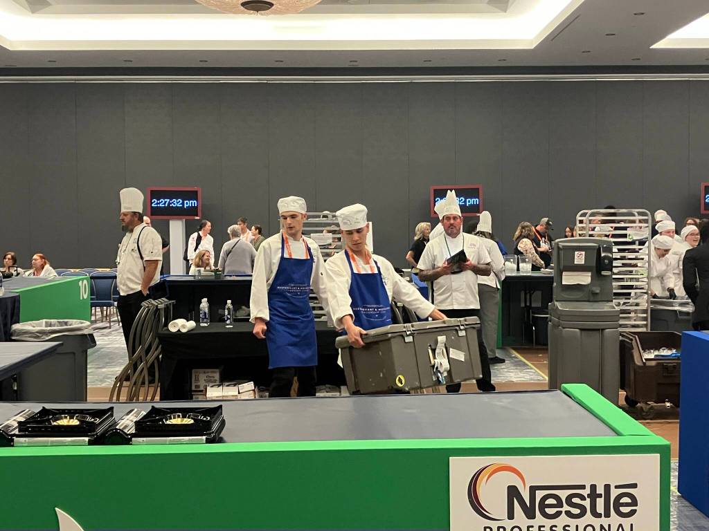 Kaeden Quinto and Calvin Knapp carry ingredients to the Thunder Mountain High School culinary art teams space, which had only two butane burners for cooking, at the National ProStart Invitational in Baltimore on April 26-28. (Photo by Rebecca Giedosh-Ruge)