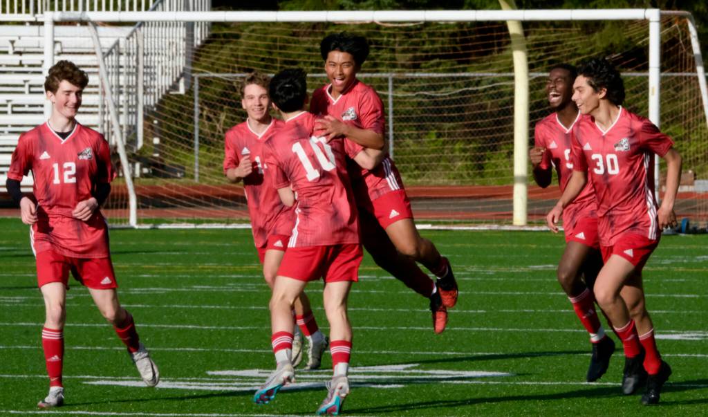 Juneau-Douglas High School: Yadaa.at Kalé freshman Sam Mazon (center) celebrates his goal with juniors Ryan Thibodeau (12), Kai Ciambor, Kellen Chester (10), Ahmir Parker (9) and senior Sonny Monsef (30) during the Crimson Bears 4-2 win over the Kings at Adair-Kennedy Field on Friday. (Klas Stolpe / For the Juneau Empire)