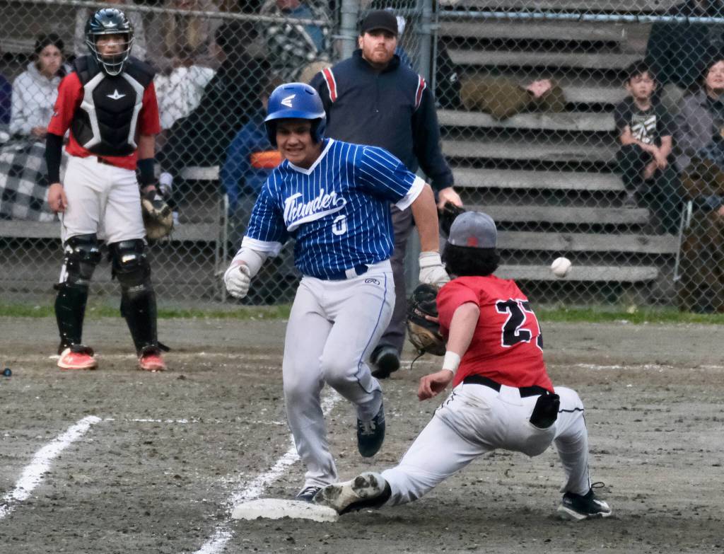 Thunder Mountain High Schools Hayden Aube races a throw to Juneau-Douglas High School: Yadaa.at Kalé first baseman Riley Fick. (Klas Stolpe / For the Juneau Empire)