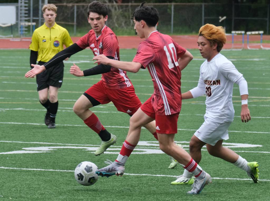 Juneau-Douglas High School: Yadaa.at Kalé senior Martin Holst calls for a ball from junior Kellen Chester (10) as Ketchikans SP Abigania chases during the Crimson Bears 2-0 region title clinching win over the Kings at Adair-Kennedy Field on Saturday. (Klas Stolpe / For the Juneau Empire)