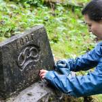 Adriana Botelho works to clean a headstone as part of restoring the Lawson Creek Cemetery on May 22, 2021. (Michael S. Lockett / Juneau Empire file photo)