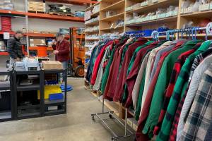 Tom Abbas discusses the hose his boat needs as shop owner and vintage halibut jacket provider Jim Geraghty shows his customer the options. Racks of dry-cleaned woolen jackets hang among the marine supply aisles in Gerahgtys Lemon Creek business. (Laurie Craig / Juneau Empire)