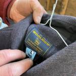 A dry cleaning tag hangs from the Woolrich jacket logo tag. Geraghty gives all jackets a professional dry cleaning before selling them. He washes his own wool in lukewarm water with Woolite. Dont put them in the dryer, he suggests, or they will shrink. (Laurie Craig / Juneau Empire)