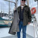 Commercial fisherman Mike Walsh wore his lightweight wool halibut shirt over a wool vest on Saturday, May 18, as he hosed the deck of his salmon troller. He stepped into the wheelhouse of his boat Silver Fox to pull out his gray Woolrich coat. The well-used and well-loved jacket  with some spots of bottom and hull paint  stays on the boat. (Laurie Craig / Juneau Empire)