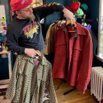 Cosmik Debriz owner Axel Gillam holds two vintage jackets in his shop on Monday, May 20. (Laurie Craig / Juneau Empire)