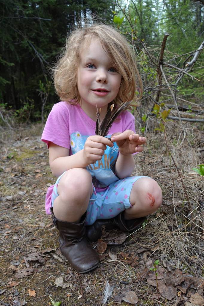 Rose Bulger, 6, holds grouse feathers she found during a family science expedition on the UAF campus. (Photo by Ned Rozell)