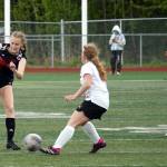 Juneau-Douglas High School: Yadaa.at Kalés Peyton Wheeler sends the ball past Kenai Centrals Kylee Verkuilen during the ASAA Soccer Division II State Championships at Veterans Memorial Field in Wasilla on Saturday, May 25. (Jake Dye/Peninsula Clarion)