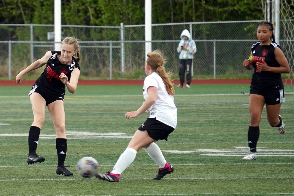 Juneau-Douglas High School: Yadaa.at Kalés Peyton Wheeler sends the ball past Kenai Centrals Kylee Verkuilen during the ASAA Soccer Division II State Championships at Veterans Memorial Field in Wasilla on Saturday, May 25. (Jake Dye/Peninsula Clarion)