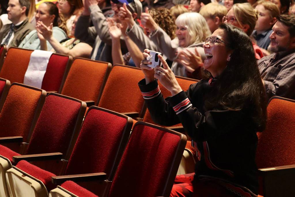 U.S. Rep. Mary Peltola takes photos of her son, Job Nelson, as he receives his diploma during Yaaḵoosgé Daakahídi High Schools graduation ceremony Sunday in the Juneau-Douglas High School: Yadaa.at Kalé auditorium. (Mark Sabbatini / Juneau Empire)