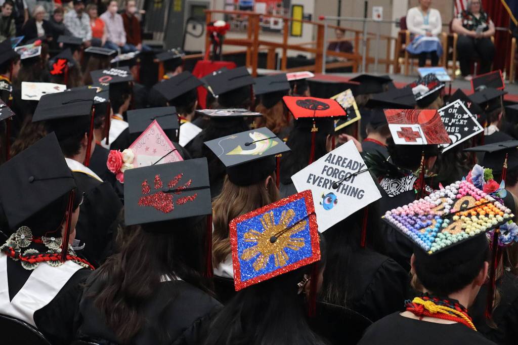An assortment of artistic decorations are seen on the tops of students caps during the graduation ceremony Sunday at Juneau-Douglas High School: Yadaa.at Kalé. (Mark Sabbatini / Juneau Empire)