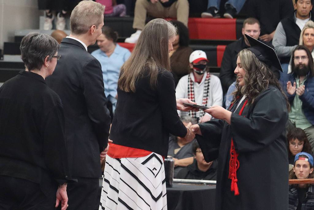 Natalia Martin receives her diploma from Juneau-Douglas High School: Yadaa.at Kalé Principal Paula Casperson during Sundays commencement ceremony. (Mark Sabbatini / Juneau Empire)