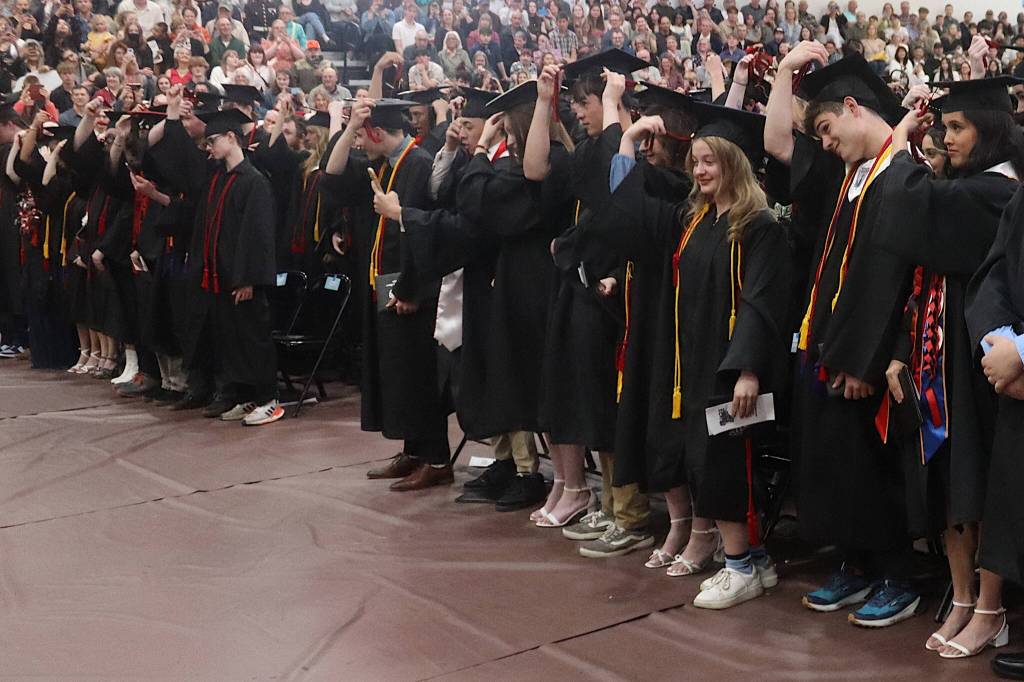 Newly graduated students at Juneau-Douglas High School: Yadaa.at Kalé move their tassels from right to left after receiving their diplomas during Sundays commencement ceremony. (Mark Sabbatini / Juneau Empire)