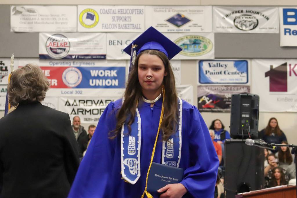 Thunder Mountain High School graduate Olivia Mills walks across the graduation stage during Sundays commencement ceremony. (Jasz Garrett / Juneau Empire)