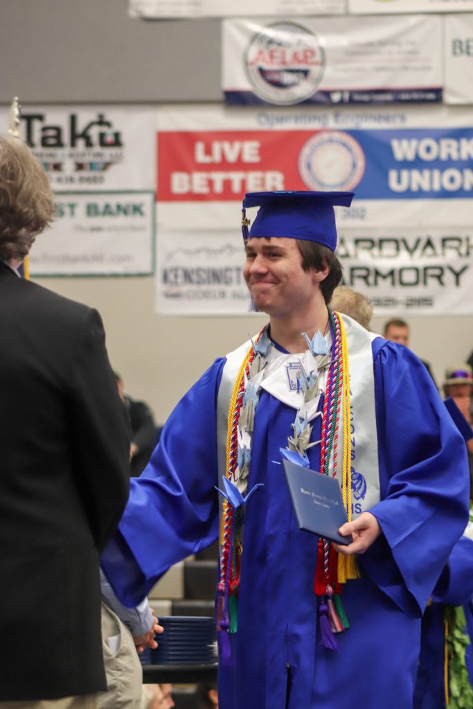 Thunder Mountain High School graduate Joshua Kessler receives his diploma during Sundays commencement ceremony. (Jasz Garrett / Juneau Empire)
