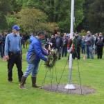 Lai Hinckle (right) and Keith Wertheimer place a wreath from the Juneau Elks Lodge 420 at the base of the flagpole at Evergreen Cemetery during a Memorial Day ceremony Monday. (Mark Sabbatini / Juneau Empire)
