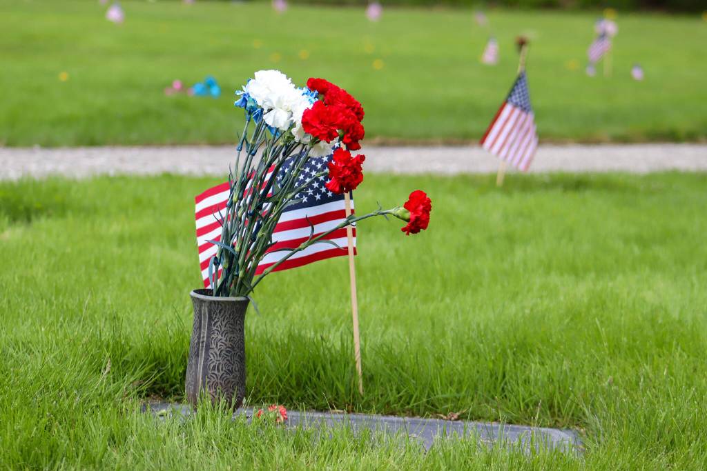 Flags decorating headstones were placed Thursday and will remain at the Alaskan Memorial Park until June 4. (Jasz Garrett / Juneau Empire)