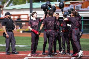 Juneau-Douglas High School: Yadaa.at Kalés Landon Simonson is greeted at home after hitting a grand slam on Friday during the Division I Alaska School Activities Association Baseball State Championships in Anchorage. (Stephanie Burgoon/Alaska Sports Report)