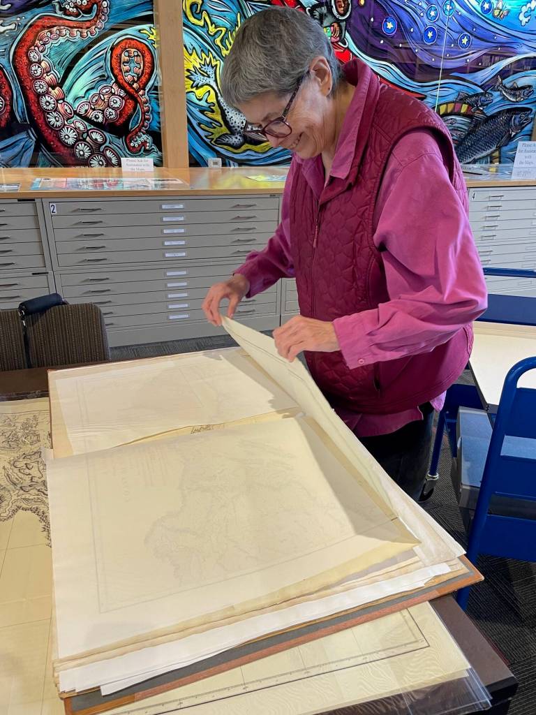 Sandy Johnston, a 32-plus-year librarian in the historical collections at the Alaska State Library, uncovers George Vancouvers Voyage of Discovery bound maps that named much of Southeast Alaska in 1794. (Laurie Craig / Juneau Empire)