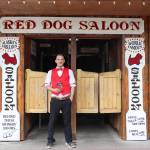 Juneau author W.R. Kozey holds his book Tall Tales of Alaska, The Red Dog Saloon: Stories from the Gold Rush & More in front of the Red Dog Saloon on Sunday. (Jasz Garrett / Juneau Empire)
